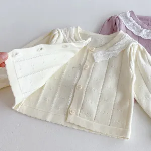 Infant baby girl knit cardigan with delicate lace collar and buttons, soft cotton texture.