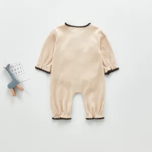 Detailansicht des gerippten Baby-Bodys in neutralem Beige mit kontrastierender Paspel.