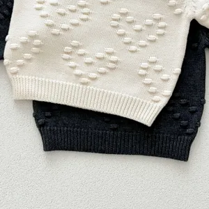Infant knit sweater detail close-up, soft textured wool fabric for autumn and winter baby wear.