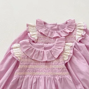 Vista ravvicinata dettagliata del dolce vestito rosa a maniche lunghe da bambina con colletto.