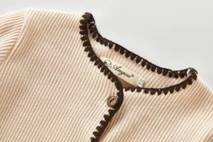 Süßes Baby Feinstrick Romper Detailfoto mit stilvollem braunem Häkelrand für Herbst.