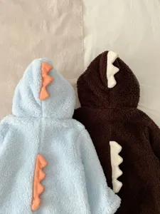 Detalle de cerca del pelele de felpa de dinosaurio para bebé con lindos picos 3D en la espalda.