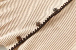 Baby Feinripp Body Detail Nahaufnahme mit weicher Textur, Bogenkante und Knöpfen.
