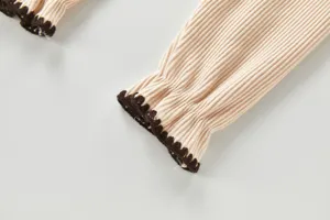 Baby Strick Strampler Ärmel Detail, kuscheliger Rippstoff mit kontrastierender Borte.