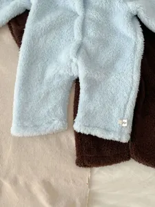 Detalle de mameluco de felpa suave para bebé, mono de invierno cálido con estilo tierno.