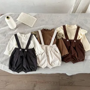 Infant baby ruffle sleeve top and corduroy overall shorts detail view, cute retro spring look.