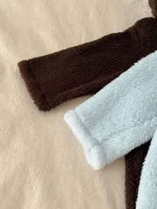 Detalle de manga de mameluco de dinosaurio para bebé de peluche suave, ropa de invierno cálida, polar.