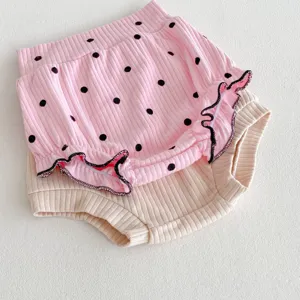 Détail de culottes bébé côtelées, adorables bloomers à pois et unis pour nouveau-né.