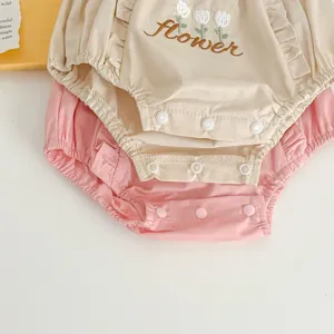 Deliziosi pantaloncini ricamati di fiori per neonata, dettaglio tutina estiva in morbido cotone.