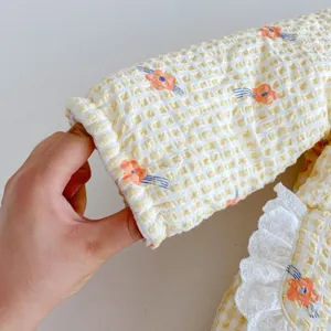 Cute baby girl winter quilted romper with yellow grid pattern and white lace collar details.