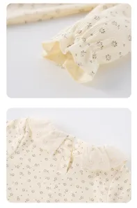 Close-up details of baby floral romper collar and ruffled sleeve, soft ribbed fabric.