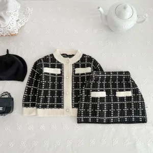 Knit cardigan and skirt set detail, black and white tweed style, elegant white trim design.