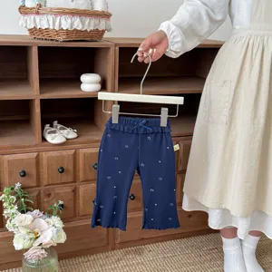 Vue detaillee de pantalon patte d'elephant bleu fonce pour bebe avec smiley et joli noeud.