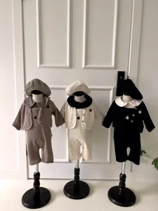 Details van het baby wafelbrei salopette set met appelmotief en bijpassende baret.