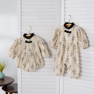 Detailed view of cute Chinese style baby floral romper set with black collar and bow.