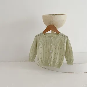 Détail de cardigan en tricot ajouré pour bébé, tissu doux, joli vêtement quotidien.