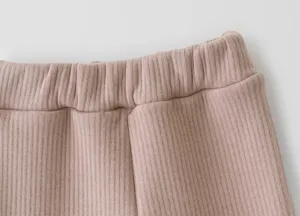 Ribbed knit waistband detail of children casual pants, soft cotton texture, close-up view.