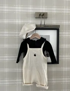 Gedetailleerd overzicht baby wafelbreisel tuinbroek, schattige herfstoutfit met appel borduurwerk.