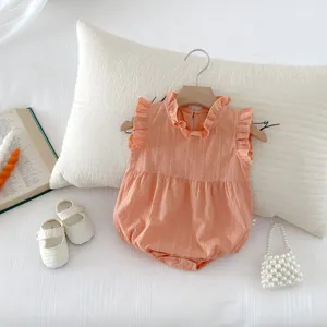 Detailed view of cute baby girl cotton sleeveless romper with cute ruffles and soft peach tone.