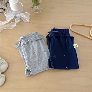 Joli pantalon évasé en coton pour bébé fille avec nœud et imprimé souriant, style décontracté.