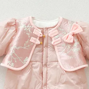 Close-up detail of a cute pink baby winter quilted jumpsuit with Chinese style buttons and bow.