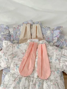 Detailed close-up of cute floral baby winter romper featuring rabbit ears and soft ruffles.