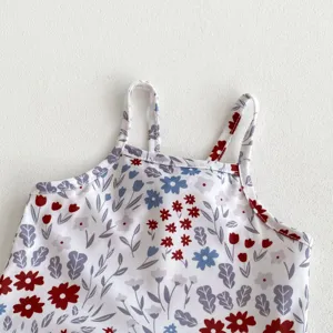 Close-up detail of floral print baby girl swimsuit with dual straps and vibrant colorful flowers.
