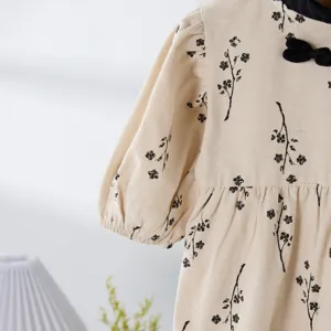 Infant baby girl floral romper sleeve detail, soft cotton beige fabric with black print.
