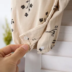 Detailed close-up view of baby floral romper showing soft fabric and snap buttons.