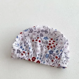 Floral print baby swim cap detail shot, showing the elastic band and delicate pattern clearly.