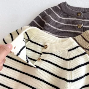 Dettaglio maglione lavorato a maglia rigato per neonato, cardigan con bottoni, morbido.