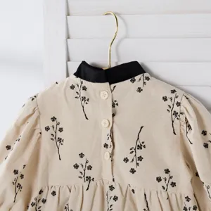 Baby floral romper detail, beige cotton fabric with black print and cute collar button back.