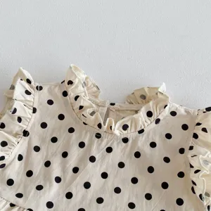 Infant baby girl sleeveless cotton top detail with black polka dots and sweet ruffles.