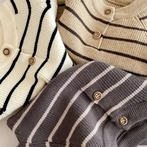 Primo piano dettagliato del cardigan in maglia a righe da neonato con morbidi bottoni.