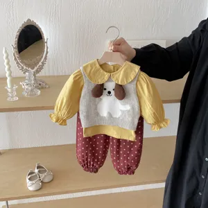 Adorable toddler baby girl outfit detail, cute dog sweater vest with yellow blouse and floral pants.