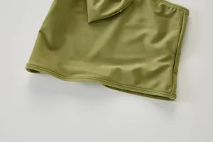 Close-up detail van olijfgroene badpak met één schouder en schattige strik voor kinderen.