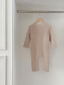 Detailaufnahme eines weichen Baby-Stramplers aus Strick in Beige mit langen Ärmeln und Rippenoptik.