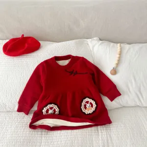 Detailed close-up view of red fleece-lined knit baby girl dress with cute rabbit embroidery.