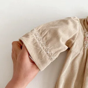 Infant corduroy dress detail close up, khaki baby girl romper with sleeve embroidery