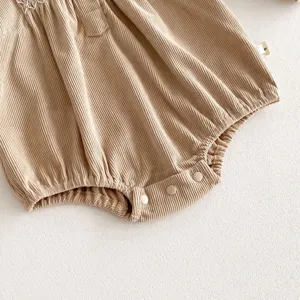 Infant corduroy baby romper detail shot, soft ribbed fabric, crotch snap buttons, cozy fit.