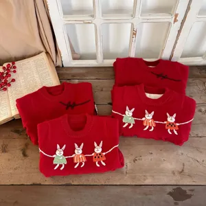 Toddler red knit sweater detail featuring cute embroidered rabbits and warm fleece lining.