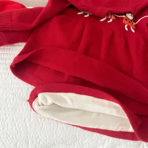 Red toddler girl knit dress detail featuring cozy white fleece lining and cute handmade embroidery.