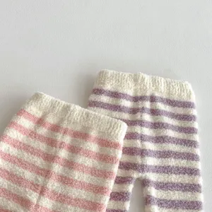 Detailed view of soft plush striped baby trousers, cozy winter fabric texture and cute pink purple.