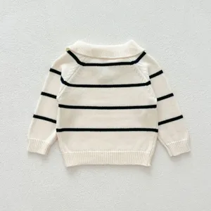 Close-up detail of infant knit sweater back, black and white stripes, soft collar.