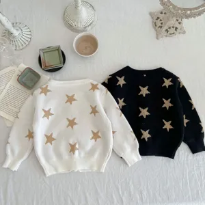 Infant knit sweater detail showing gold star patterns on black and white toddler cardigans.