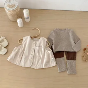 Vue détaillée d'un ensemble de printemps pour bébé confortable avec gilet et haut en tricot.