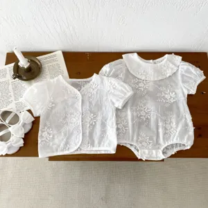 Infant baby girl white cut-work short sleeve doll collar romper and cardigan detail view.