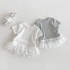 Gros plan détail de t-shirts manches courtes pour filles avec ourlet en dentelle délicate.