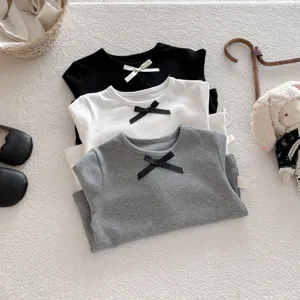 Close-up detail view of cute ribbed long sleeve kids t-shirts stacked in three colors.