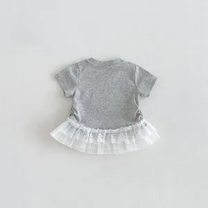 Détail de t-shirt gris à manches courtes pour fille avec ourlet en dentelle blanche.